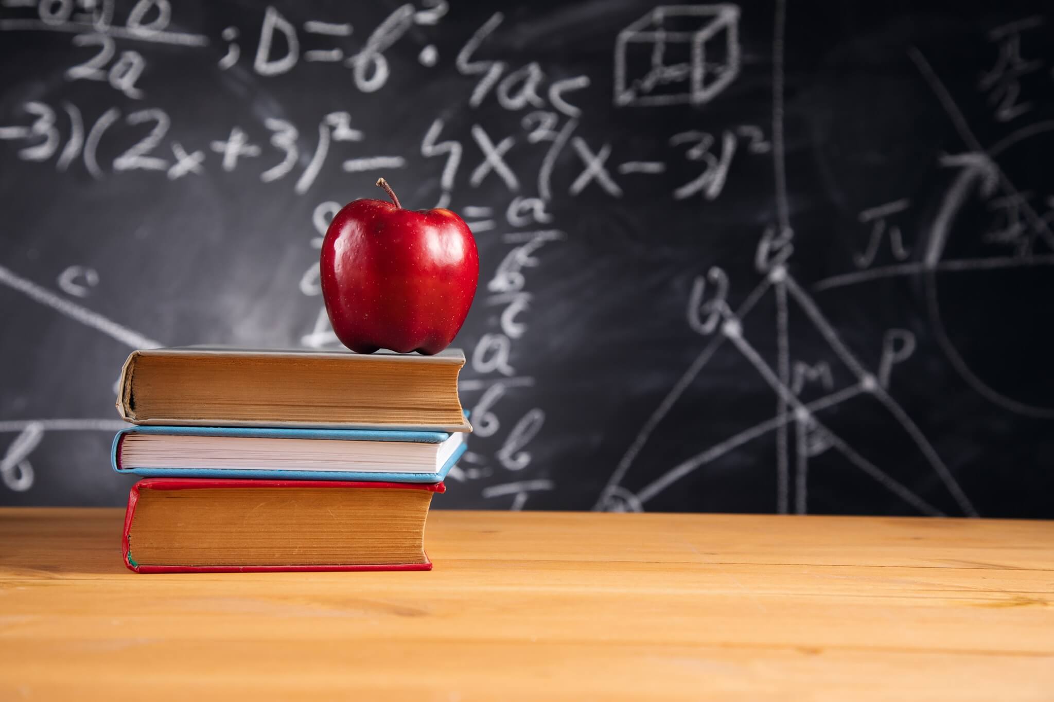 Apple On Books With Blackboard Background